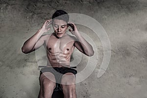 Muscular man doing abdominal sit ups on studio