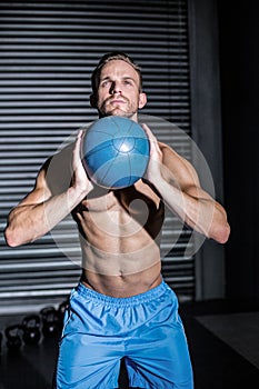 Muscular man doing ball exercise