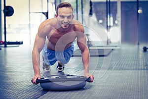 Muscular man doing bosu ball exercises