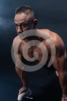 Muscular man doing calisthenic exercise isolated on the black background