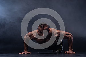 Muscular man doing calisthenic exercise isolated on the black background