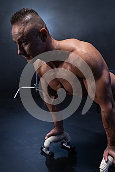 Muscular man doing calisthenic exercise isolated on the black background