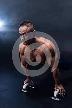 Muscular man doing calisthenic exercise isolated on the black background