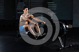 Muscular man doing exercise for legs in the gym