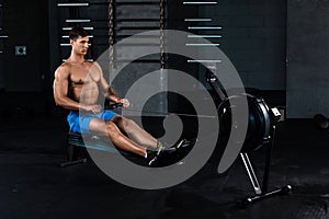 Muscular man doing exercise for legs in the gym