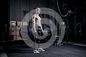 Muscular Man Doing Heavy Deadlift Exercise. Dramatic color grading.