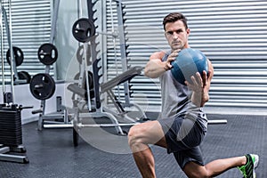 Muscular man doing medecine ball exercises