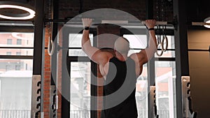 Muscular man doing pull up exercise.
