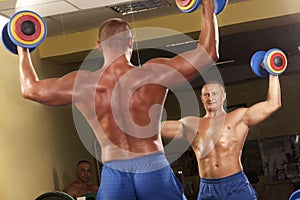 Muscular man doing weightlifting in gym
