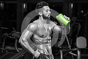 muscular man drinking water in gym, shaped abdominal. Strong male torso abs, working out
