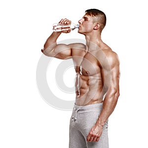 Muscular man drinking water, isolated on white background