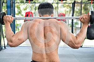 Muscular man execute exercise in fitness center. male athlete pu