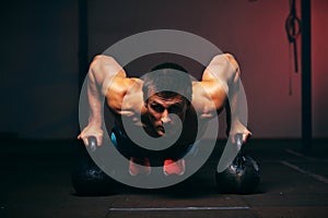 Muscular man exercising with kettle bell in gym