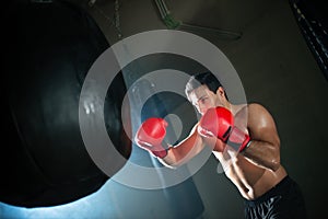 Muscular man fighting with punching bag