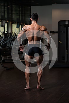 Muscular Man Flexing Back Muscles Pose