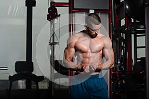 Muscular Man Flexing Muscles In Gym