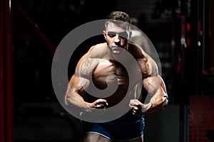 Muscular Man Flexing Muscles In Gym