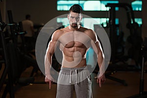 Muscular Man Flexing Muscles In Gym