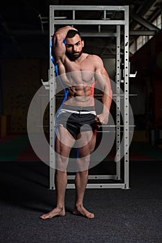 Muscular Man Flexing Muscles In Gym