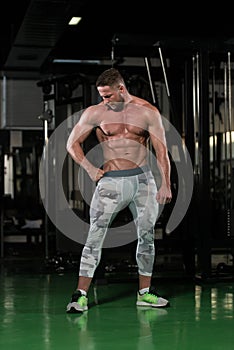 Muscular Man Flexing Muscles In Gym