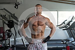 Muscular Man Flexing Muscles In Gym