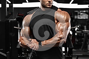 Muscular man in gym, biceps muscles. Strong male