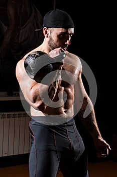 Muscular man in the gym picks up with kettlebell.