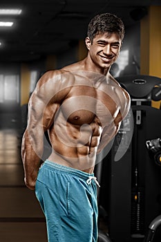 muscular man in gym, shaped abdominal. Strong male naked torso abs, working out