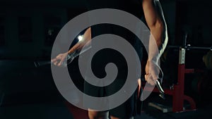 Muscular man in the gym, training legs jumping with a rope with the concept of bar selection of fitness and bodybuilding