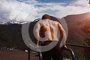 Muscular man during his outdoor workout in the mountains.