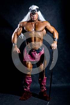 Muscular man in the image based on the barbarian sword. photo