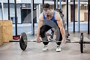 Muscular man lifting barbell