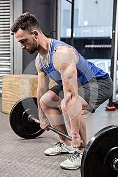 Muscular man lifting barbell