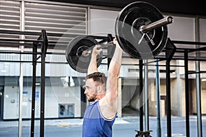 Muscular man lifting barbell
