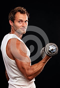 Muscular man lifting dumbbell