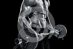 Muscular man lifting weights over dark background