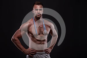 Muscular man with measurement tape