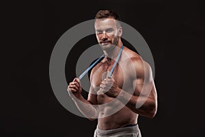 Muscular man with measurement tape