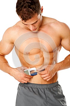 Muscular man measures level of fat on his body