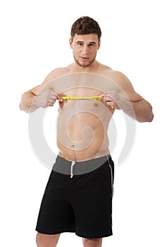 Muscular man measuring his chest.