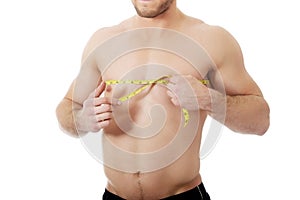 Muscular man measuring his chest.