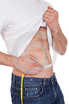 Muscular man measuring waist