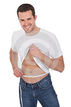 Muscular man measuring waist