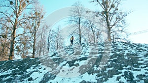 Muscular man with a naked torso with a ballon compressed air drager on his back and full face mask climbs a snowy hill