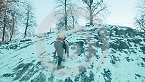 Muscular man with a naked torso with a ballon compressed air drager on his back and full face mask climbs a snowy hill