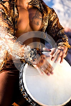 Muscular man playing drum.