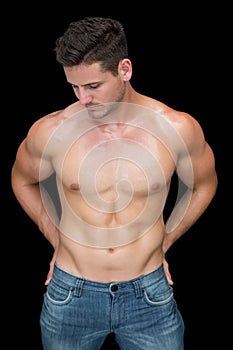 Muscular man posing in blue jeans