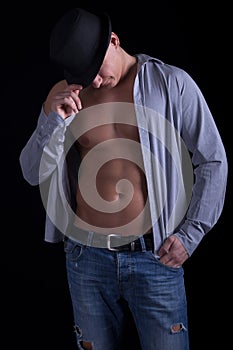 A muscular man posing with hat,on black background