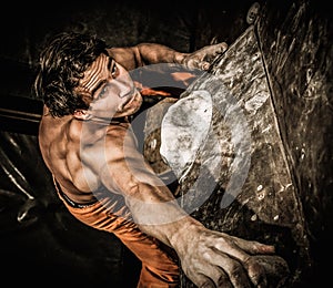 Muscular man practicing rock-climbing