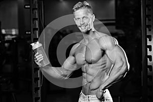 Muscular Man Resting After Exercise And Drinking From Shaker